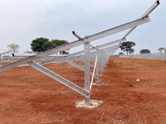 Estruturas metálicas de usina solar fixadas em solo vermelho