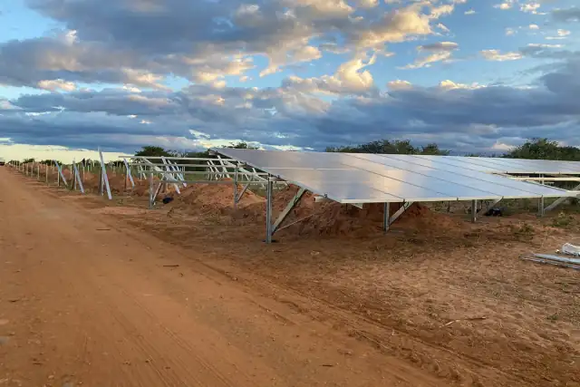 Fileiras de módulos fotovoltaicos instalados em usina solar de solo